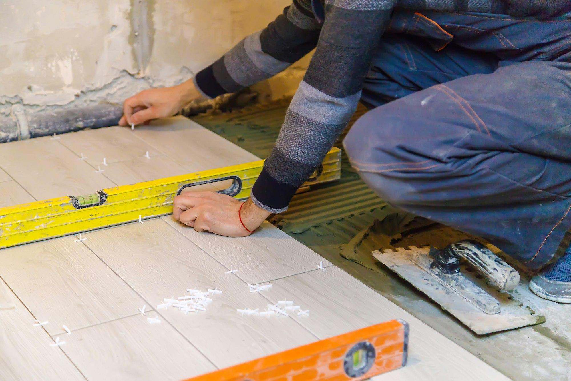 lay tiles on the floor in the house. Selective focus.